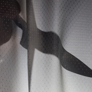 Backlit knife behind a curtain