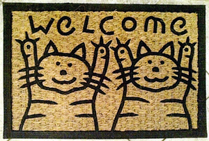 Welcome mat with cartoon cats holding up both front paws in greeting