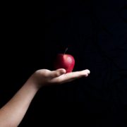 A hand holding out an apple