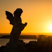 Statue of angel against sunset