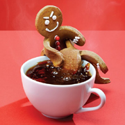 Gingerbread man drowning another gingerbread man in coffee