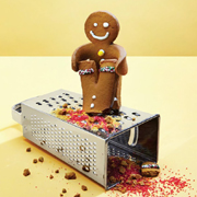 Gingerbread man cheerfully grating another gingerbread man