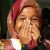Little African girl in headscarf laughs and covers her face